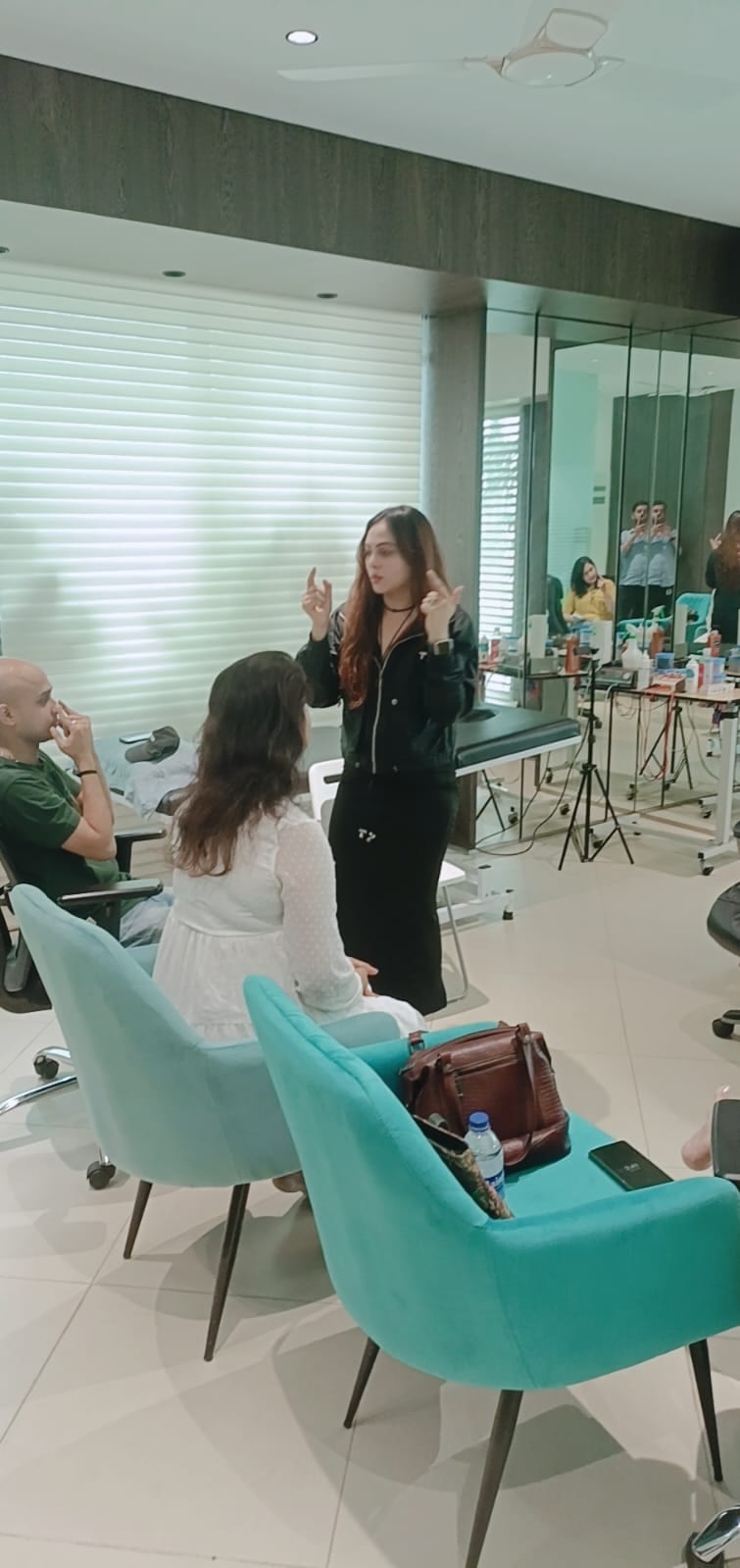 Vibha Jain standing in a consulting room, gesturing as she talks through an exercise with seated participants.